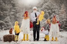 a man standing in the snow with chickens and roosters on his feet while wearing costumes