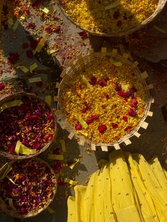 baskets filled with yellow and red flowers on top of a table next to other bowls