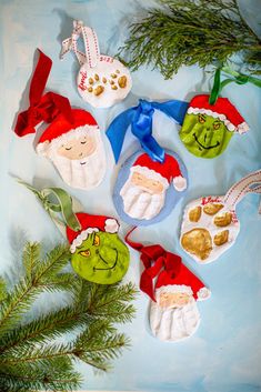 christmas ornaments made out of felt and fabric on a blue surface next to pine branches