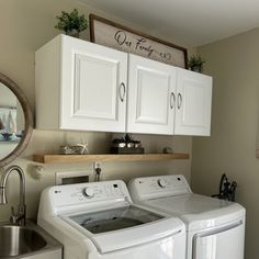 a washer and dryer in a laundry room with cabinets above the washer