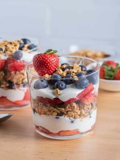 three glasses filled with yogurt and fruit on top of a polka dot napkin