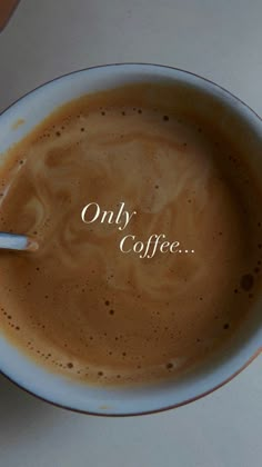 a cup of coffee with the words only coffee on it and a spoon in it