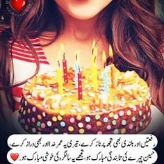 a woman holding a birthday cake with lit candles on it in front of her face