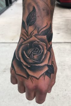 a hand with a rose tattoo on it