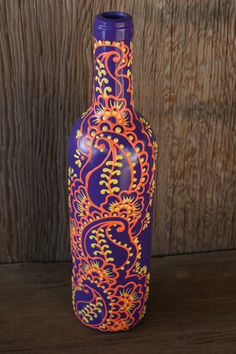 a purple and orange vase sitting on top of a wooden table