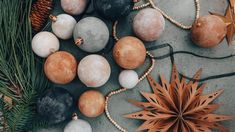 some ornaments are laying on the ground next to pine cones and other items for decoration