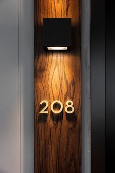 a wooden door with a light on it and the number 2088 written in gold