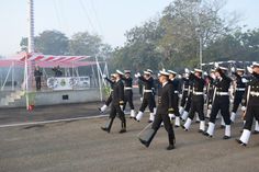 a group of men in uniform marching down the street