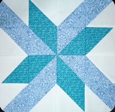 a blue and white quilted block with an arrow on the center is featured in this image