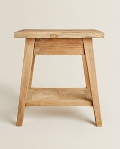 a small wooden stool sitting on top of a white floor