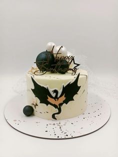 a white cake decorated with black and gold decorations