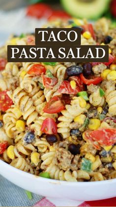 a white bowl filled with pasta salad on top of a checkered table cloth