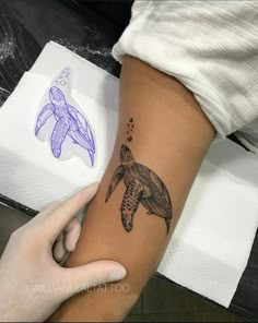 a woman's arm with a tattoo on it that has a turtle and seagull on it