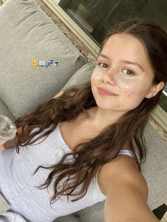 a woman sitting on a couch with a glass of wine in front of her face