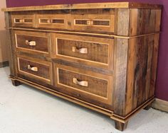 a large wooden dresser sitting in front of a purple wall with drawers on each side