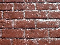 a red brick wall with small white dots on the top and bottom part, as well as some other bricks