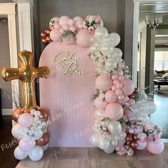 a pink and gold balloon arch with balloons