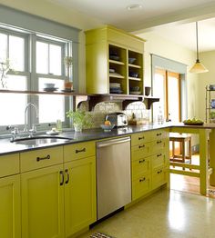 a kitchen with yellow cabinets and stainless steel appliances