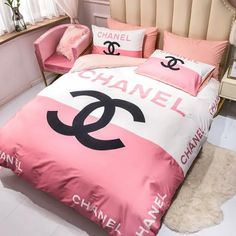 a pink and white bed with chanel pillows