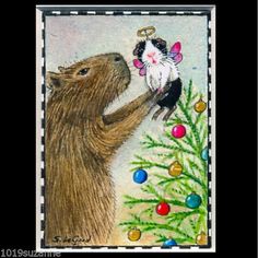 an animal and a mouse are touching each other's noses in front of a christmas tree