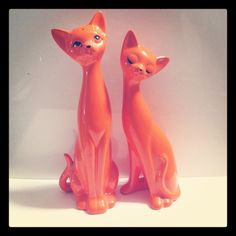 two orange cat figurines sitting next to each other