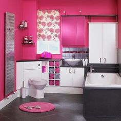 a bathroom with pink walls and grey flooring