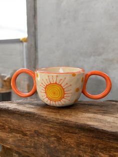 an orange and white cup sitting on top of a wooden table