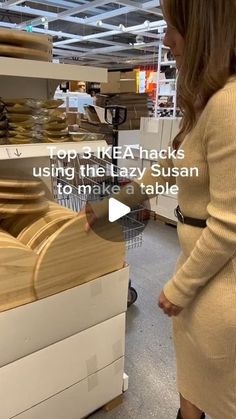 a woman standing in front of stacks of plates and looking at the shelf with text on it