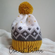 a crocheted hat with a yellow pom - pom on the top