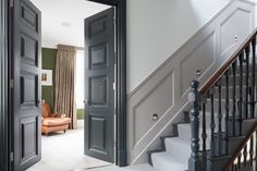 an open door leading to a living room next to a stair case in a house