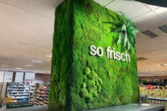 a display in a store with moss growing on the wall and so fresh sign above it