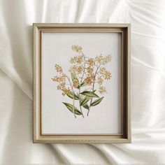 an image of flowers in a frame on the bed