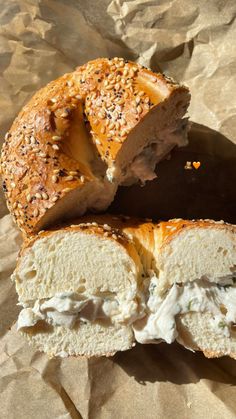 a bagel cut in half on top of brown paper