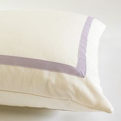 a close up of a pillow on a white surface with a purple stripe down the middle