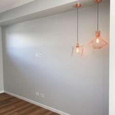 an empty room with three lights hanging from the ceiling