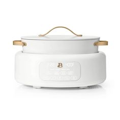 a white crock pot with gold handles on the top and bottom, sitting in front of a white background