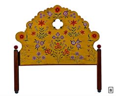 an ornate wooden headboard with flowers painted on it