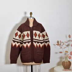 So in love with this perfect 1970s hand knit Cowichan sweater jacket. Gorgeous autumn pallet and minimalist graphic motif that wraps around. Heavy duty front zip and front pockets. Cozy heavy weight. Perfect for fall/winter. Good condition with normal wear to knit for age.  MEASUREMENTS: BUST: 46" WAIST: 46" HIP: 46" LENGTH: 28" Dark Academia Knitting, Retro Knitted Outerwear For Fall, Retro Knit Cardigan For Fall, Brown Retro Knit Sweater, Retro Brown Knitted Sweater, Retro Brown Knit Sweater, Retro Wool Cardigan With Fair Isle Pattern, Vintage Knitted Brown Outerwear, Retro Fair Isle Pattern Cardigan For Fall