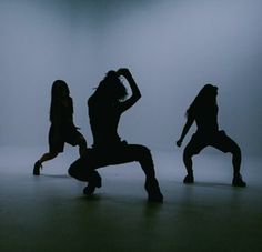 three silhouettes of people dancing in the dark