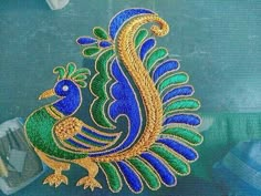 a blue and green peacock with gold accents on it's back window sill