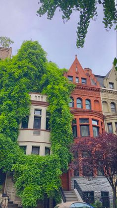 a car parked in front of a tall building with ivy growing on it's side