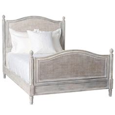 a bed with white linens and pillows on it's headboard, in front of a white background