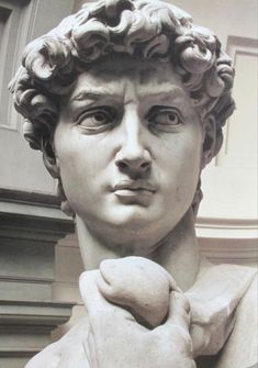 a close up of a statue of a man with his hand on his face and hands clasped to his chest