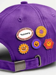 a purple hat with several different badges on the front and back of it, all in various shapes and sizes