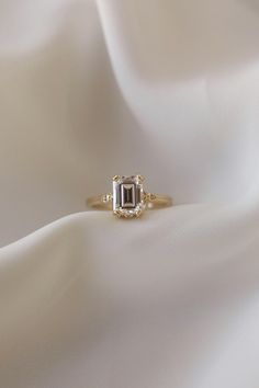 an engagement ring on top of a white cloth