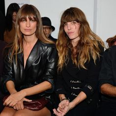 two women sitting next to each other at a fashion show