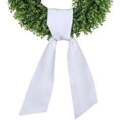 a white bow tied around a green wreath