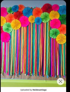 there are many colorful paper umbrellas on the wall