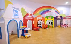 the children's playroom is brightly colored and has toys on the wooden floor