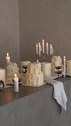 a table topped with lots of cakes and candles